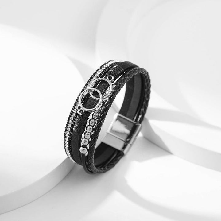Elegant damarmband i läder, flera lager, dekorerat med guldpärlor för sofistikerad stil och justerbar komfort.