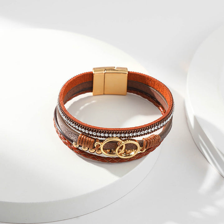 Elegant damarmband i läder, flera lager, dekorerat med guldpärlor för sofistikerad stil och justerbar komfort.