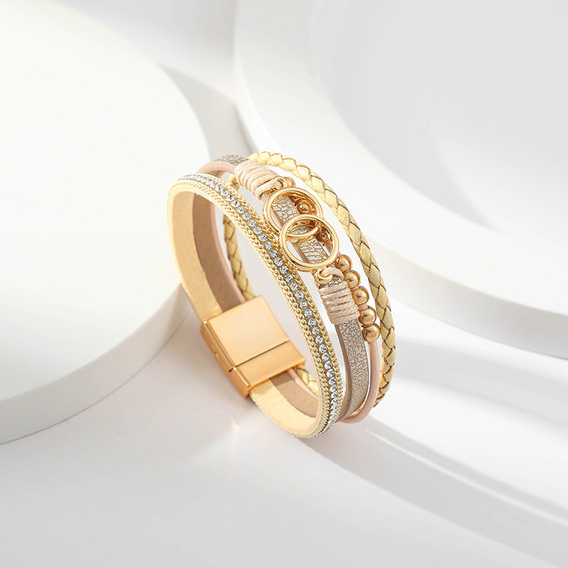 Elegant damarmband i läder, flera lager, dekorerat med guldpärlor för sofistikerad stil och justerbar komfort.