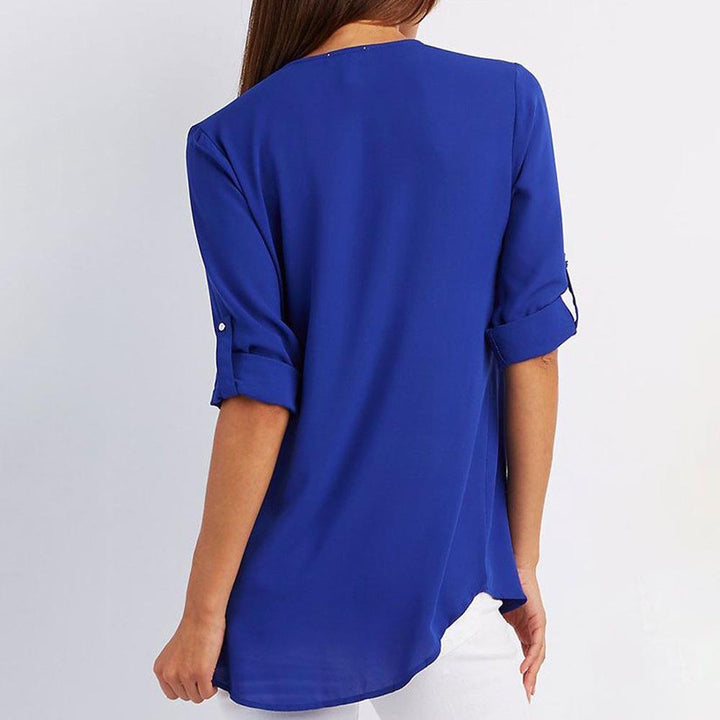 "Elegant damblusa med V-ringning och justerbar dragkedja, finns i flera färger; perfekt för stil och komfort."