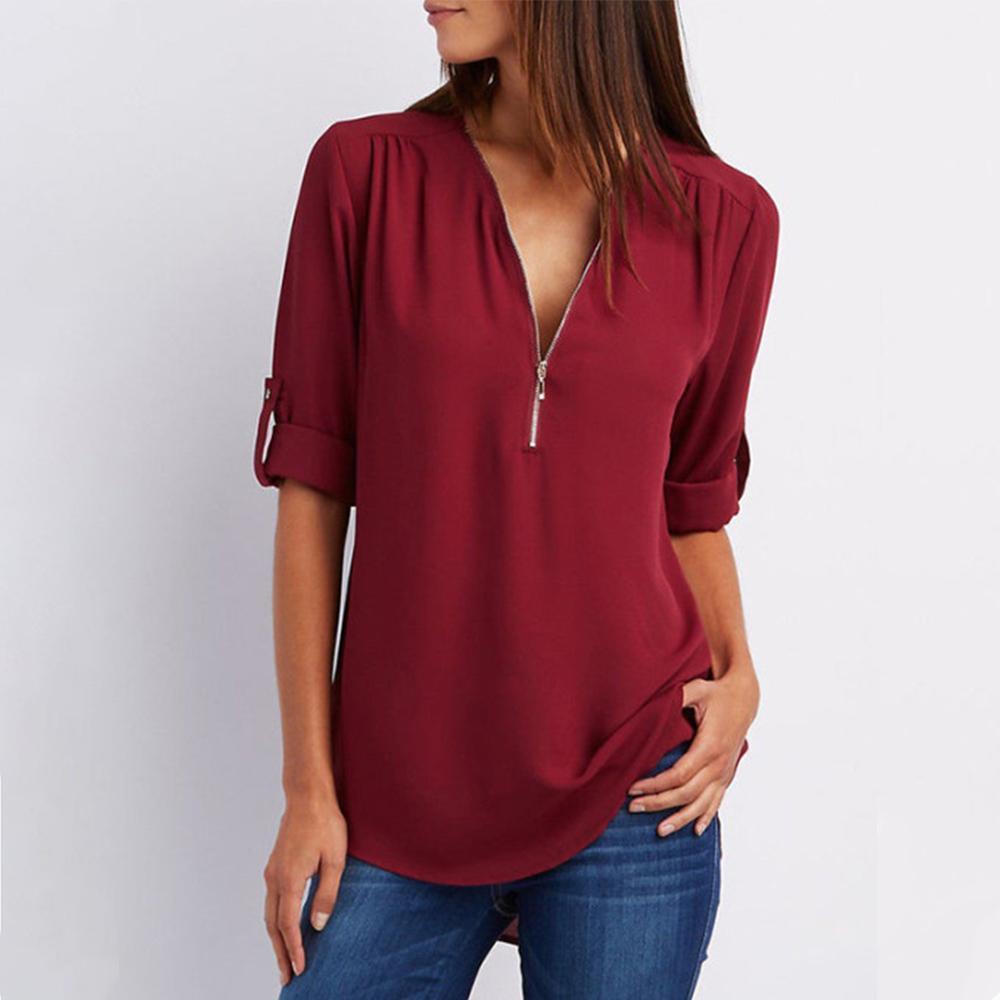 "Elegant damblusa med V-ringning och justerbar dragkedja, finns i flera färger; perfekt för stil och komfort."