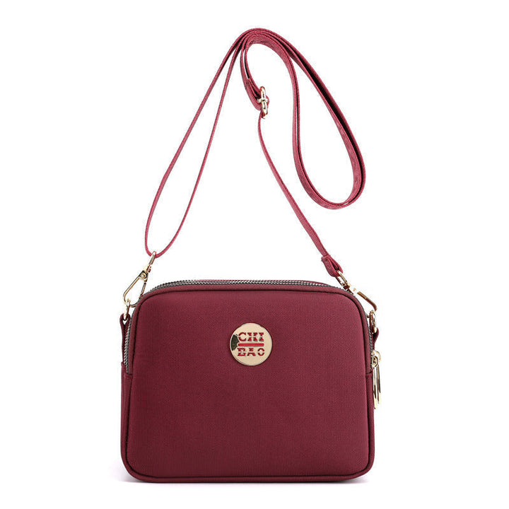 Elegant damers nylon crossbody kurirväska med multifickor, justerbar axelrem, tillgänglig i flera färger.