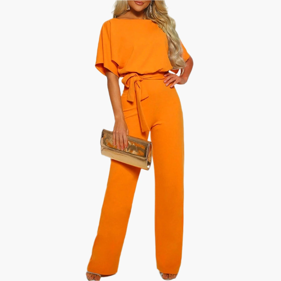 Kvinna i elegant damjumpsuit med breda ben och ärmdetalj, redo för fest eller middag. Dammode.