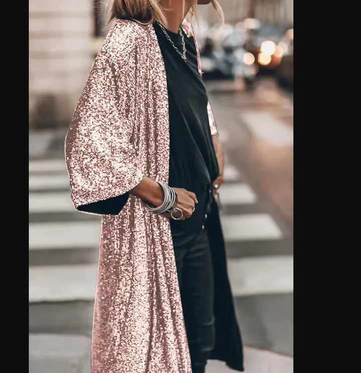 Svart paljettkimono för kvinnor, hänger uppvikt, redo att bäras som chic festkläder.
