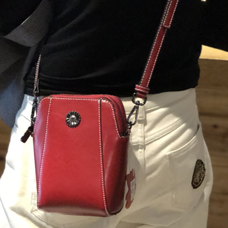 "Elegant damkurirväska i oljevaxat äkta läder, tidlös design, justerbar rem, perfekt för både vardags- och formella kläder."