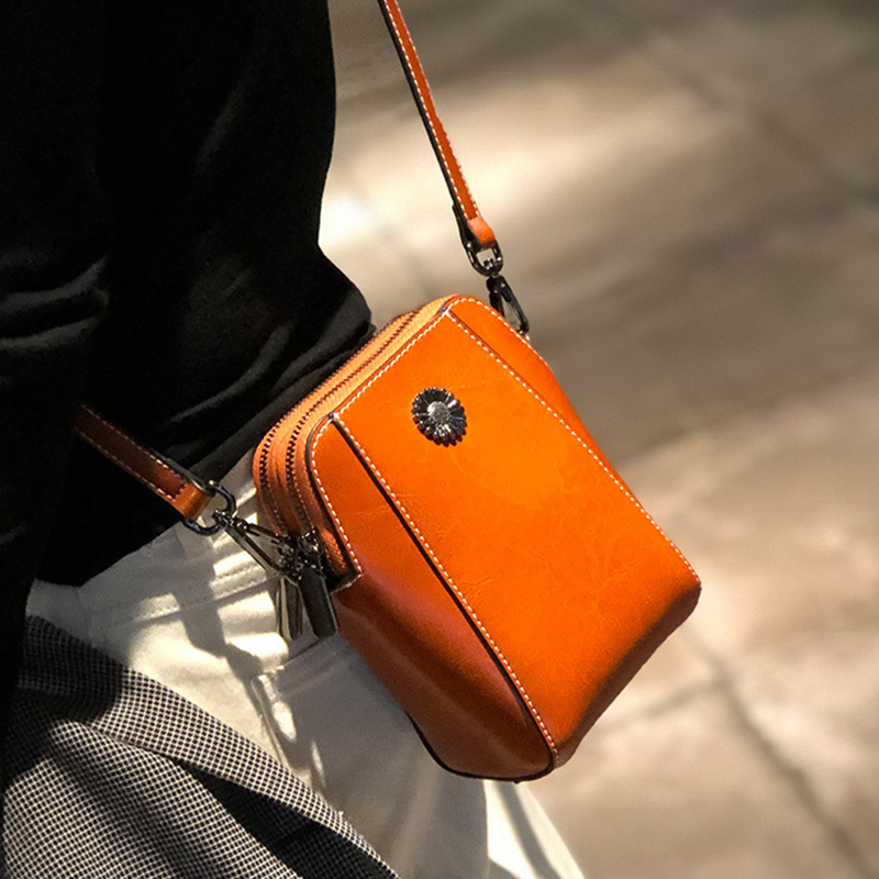 "Elegant damkurirväska i oljevaxat äkta läder, tidlös design, justerbar rem, perfekt för både vardags- och formella kläder."