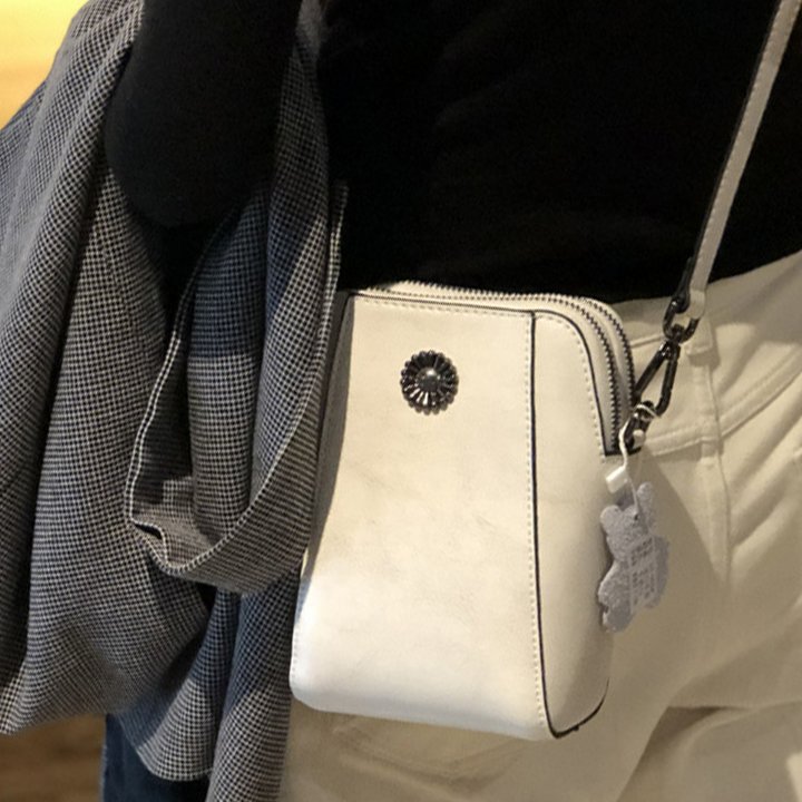 "Elegant damkurirväska i oljevaxat äkta läder, tidlös design, justerbar rem, perfekt för både vardags- och formella kläder."