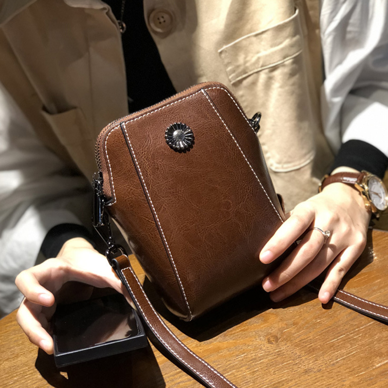 "Elegant damkurirväska i oljevaxat äkta läder, tidlös design, justerbar rem, perfekt för både vardags- och formella kläder."