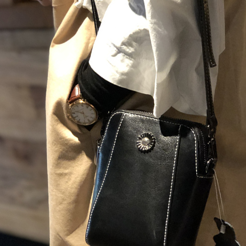 "Elegant damkurirväska i oljevaxat äkta läder, tidlös design, justerbar rem, perfekt för både vardags- och formella kläder."