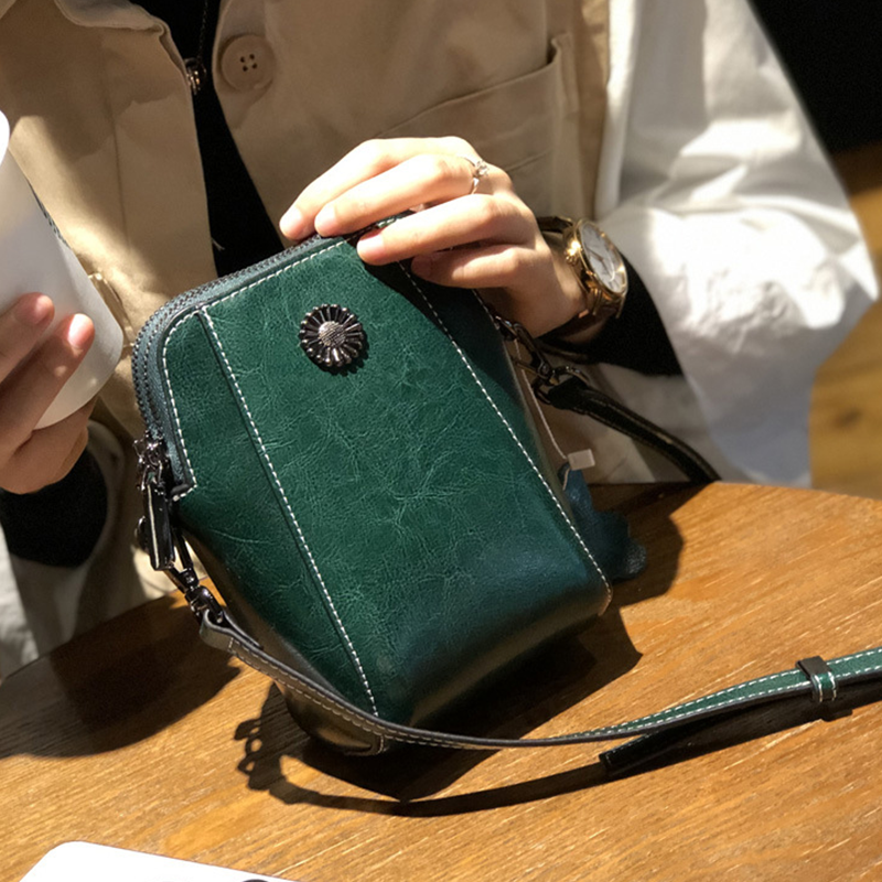 "Elegant damkurirväska i oljevaxat äkta läder, tidlös design, justerbar rem, perfekt för både vardags- och formella kläder."
