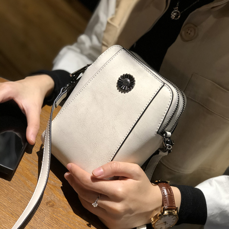 "Elegant damkurirväska i oljevaxat äkta läder, tidlös design, justerbar rem, perfekt för både vardags- och formella kläder."