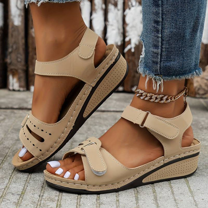 Modern damsandalett med kilklack. Elegant, lättviktssandal med öppen tå som är enkel att ta på och av.