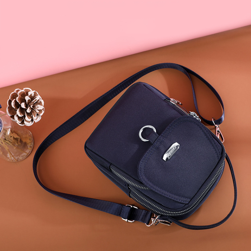 "Elegant damväska i vattentätt nylon med flera fickor, justerbar rem, perfekt för dagligt bruk och resor."