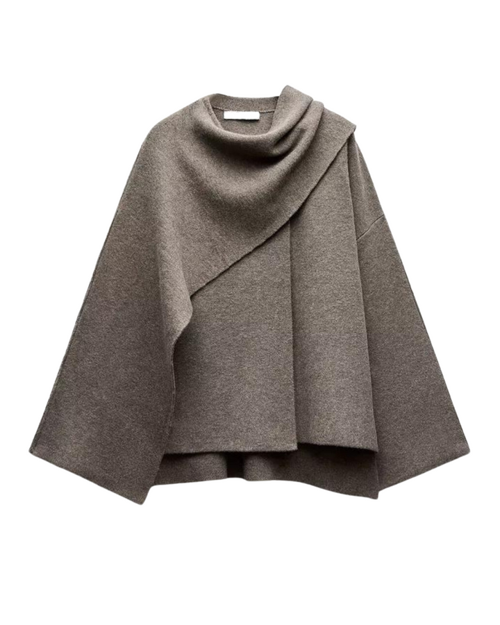 Kvinnors moderiktiga capekappa, draperade detaljer ger en sofistikerad silhuett