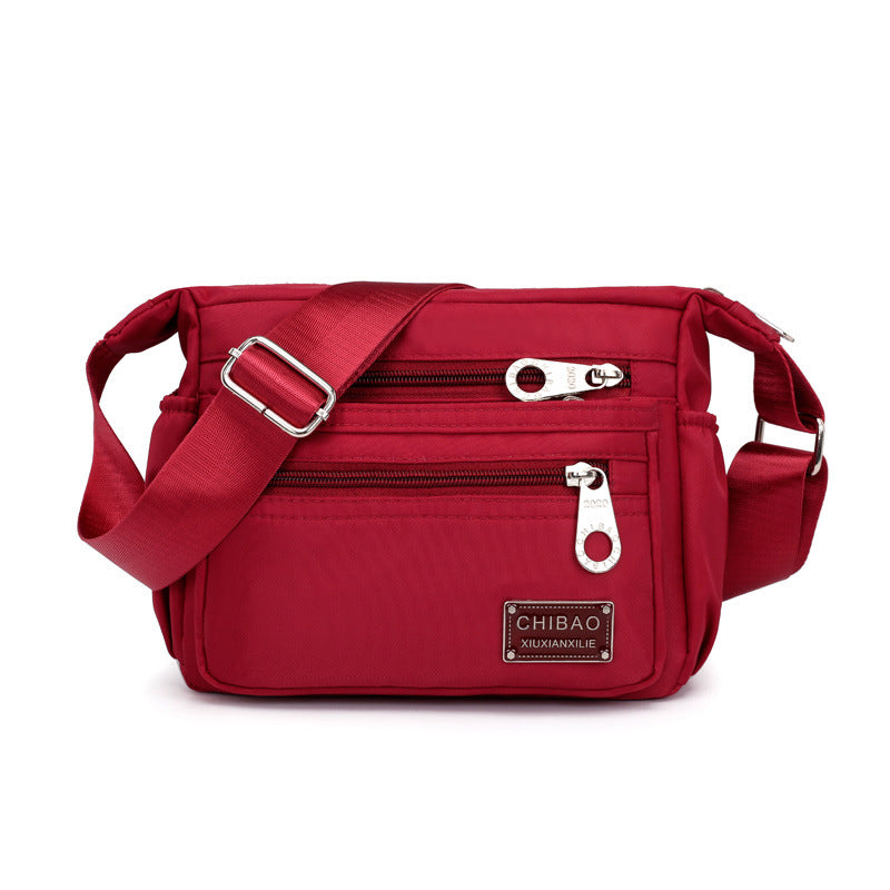 "Elegant flerlagers crossbodyväska i nylon för kvinnor, flera fack, vattentät, lämplig för mobiler och nycklar."