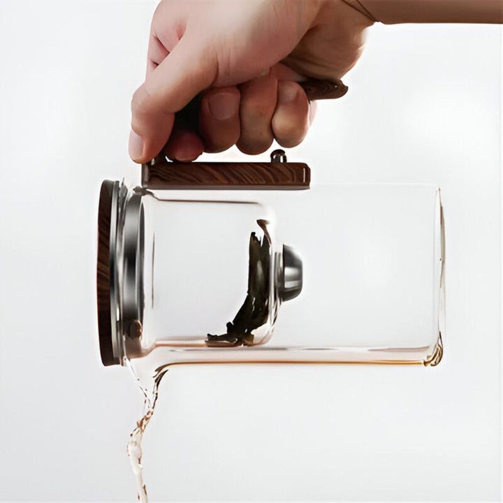 Närbild på glastekannans eleganta design och den effektiva tesilen för löste. Köksutrustning.