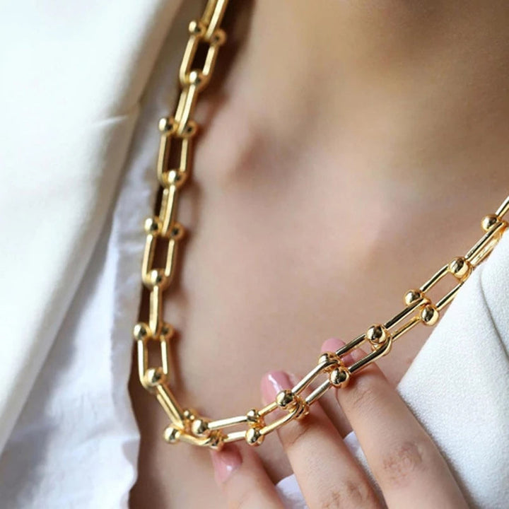 Komplett guld länkset för dam, bestående av elegant halsband och matchande armband.