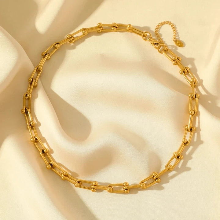 Guldpläterat länkset med glänsande halsband och matchande armband, eleganta guldsmycken.