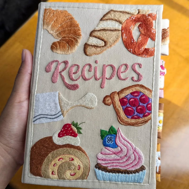 Vackert broderat omslag på handgjord receptjournal. Stilren design för att spara dina bästa matrecept.