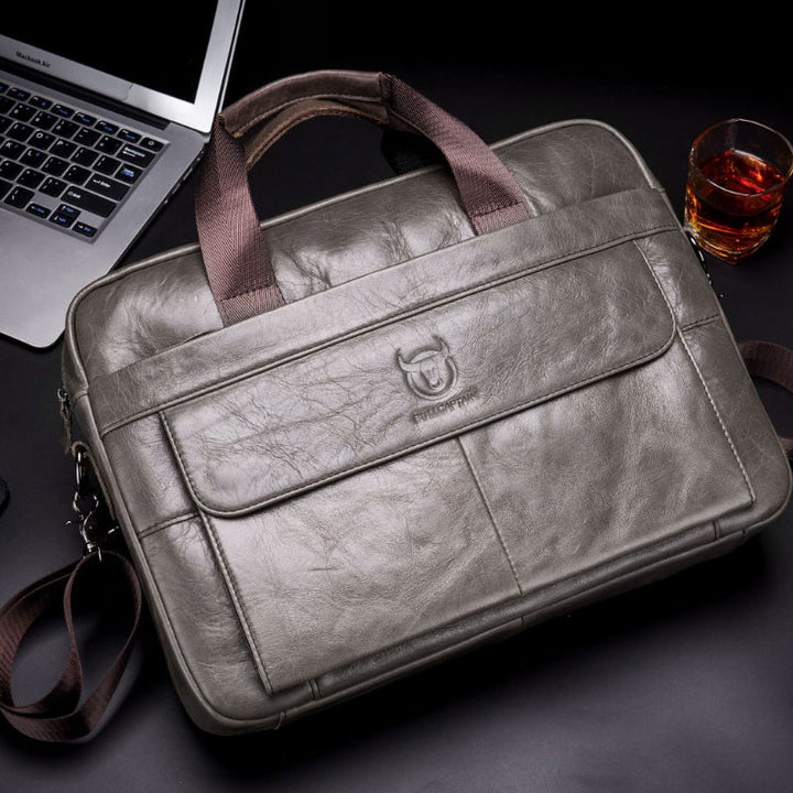 "Elegant herr läder affärsväska i kohud, framsida med premium metalldetaljer för stilmedvetna professionella."