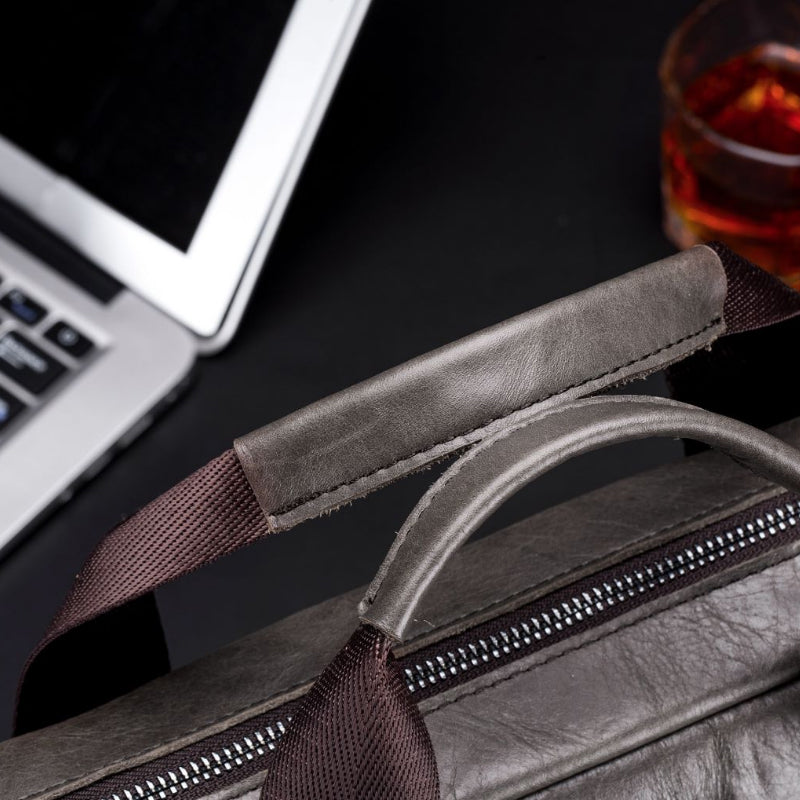 "Elegant herr läder affärsväska i kohud, framsida med premium metalldetaljer för stilmedvetna professionella."