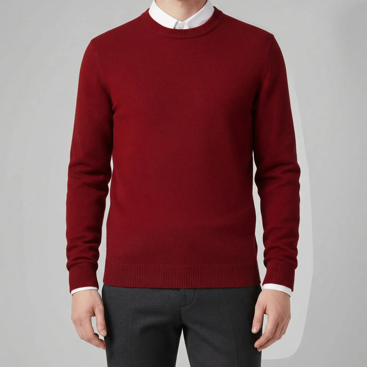 Man bär en stilren rundhalsad herrtröja, ett elegant basplagg i stickad design för vardagsmode.