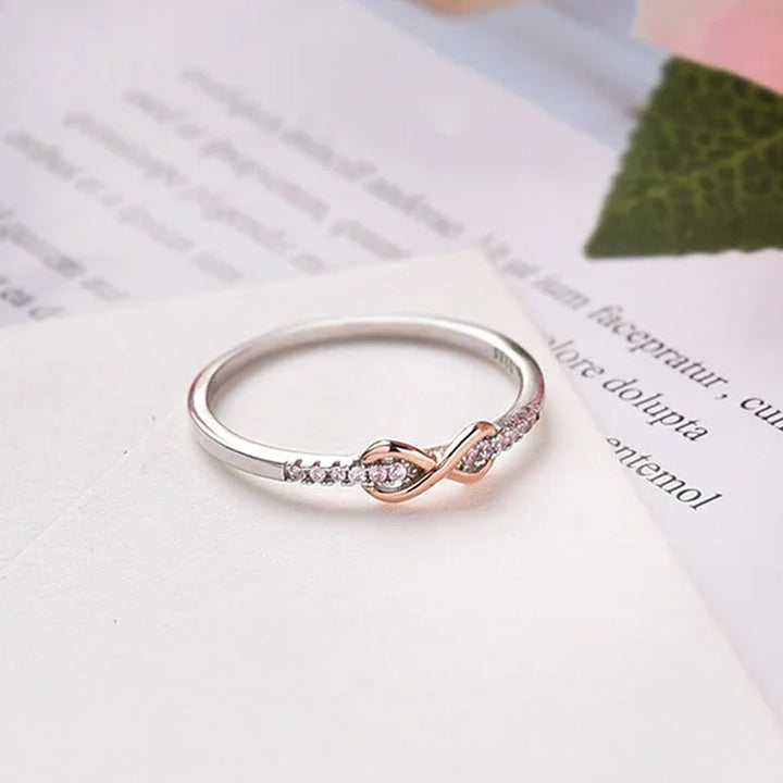 "Elegant infinityring för damer, symboliserar evig kärlek med oändlig knut, tillgänglig i rosa guld, silver, guld."