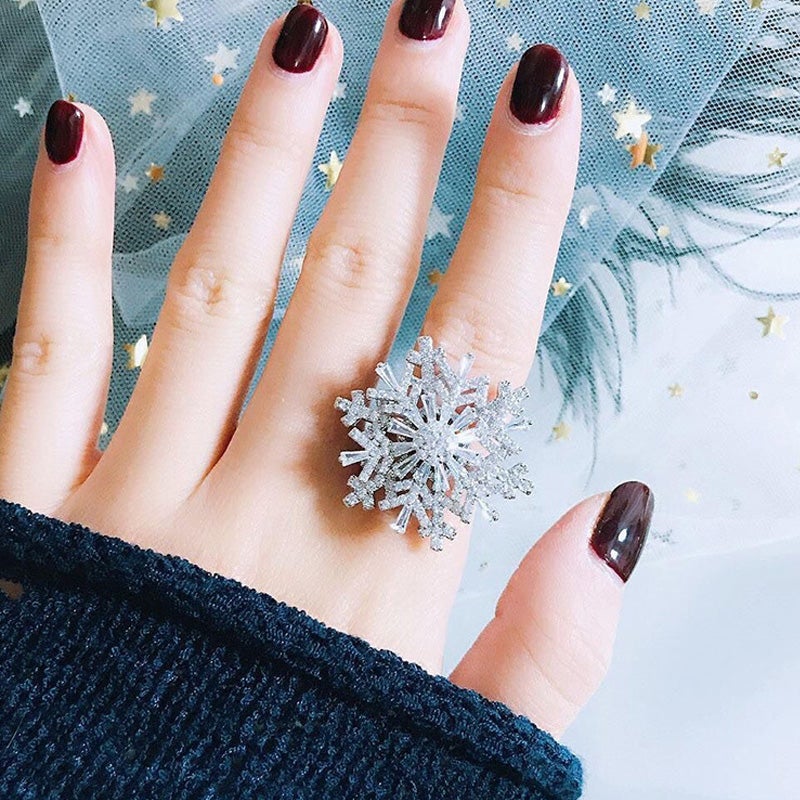 "Elegant justerbar damring med iögonfallande snöflingedesign, tillverkad i koppar och zirkon, perfekt accessoar."
