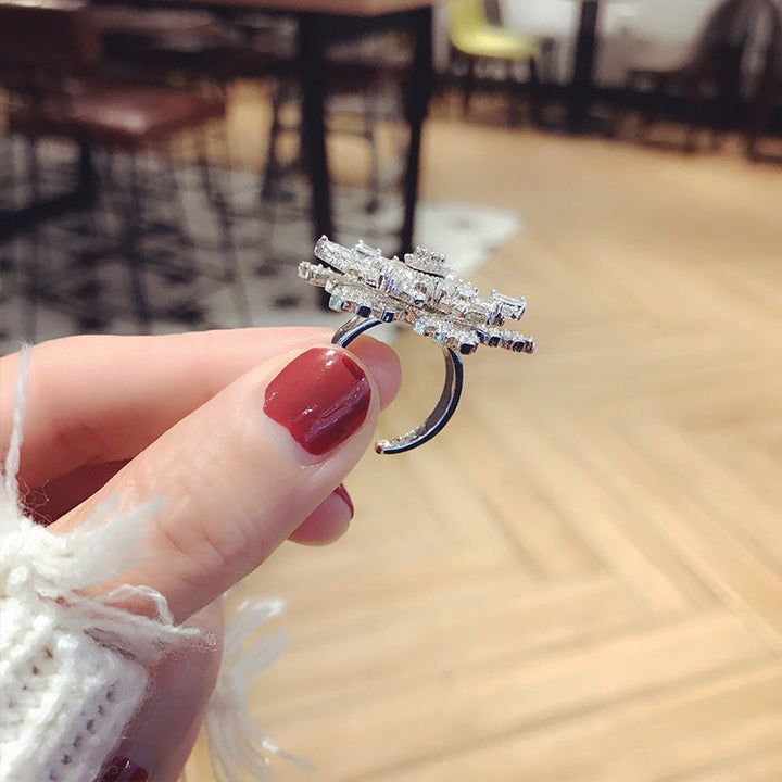 "Elegant justerbar damring med iögonfallande snöflingedesign, tillverkad i koppar och zirkon, perfekt accessoar."