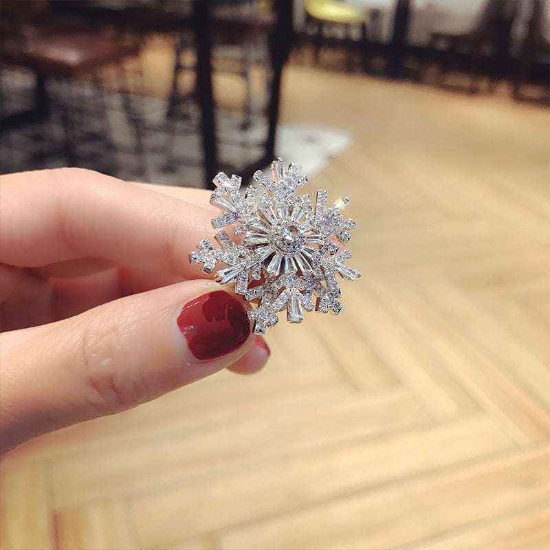 "Elegant justerbar damring med iögonfallande snöflingedesign, tillverkad i koppar och zirkon, perfekt accessoar."