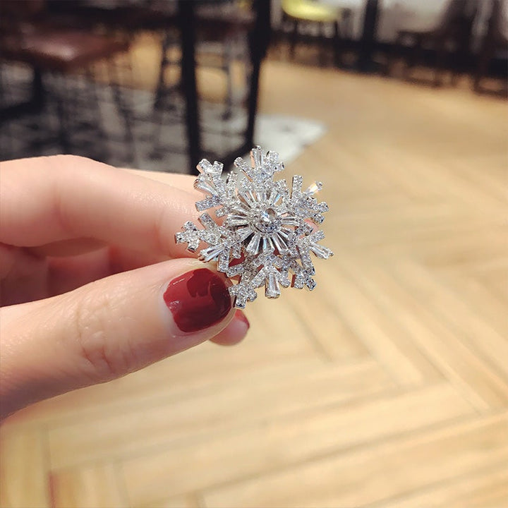 "Elegant justerbar damring med iögonfallande snöflingedesign, tillverkad i koppar och zirkon, perfekt accessoar."