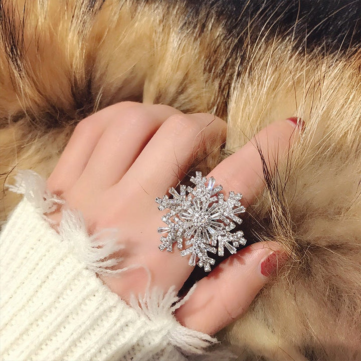 "Elegant justerbar damring med iögonfallande snöflingedesign, tillverkad i koppar och zirkon, perfekt accessoar."