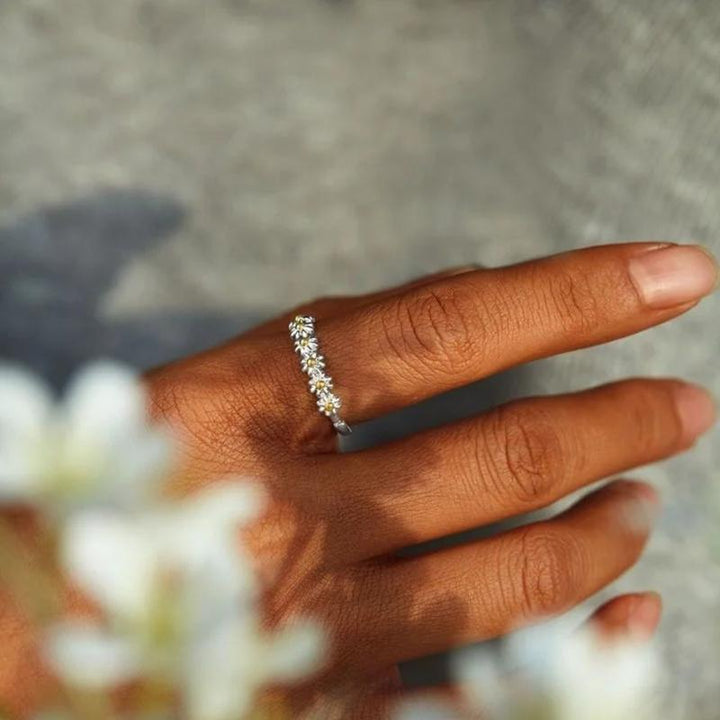 "Elegant justerbar ring för kvinnor med små tusenskönor, silverfärgad, symboliserar glädje och oskyldighet."