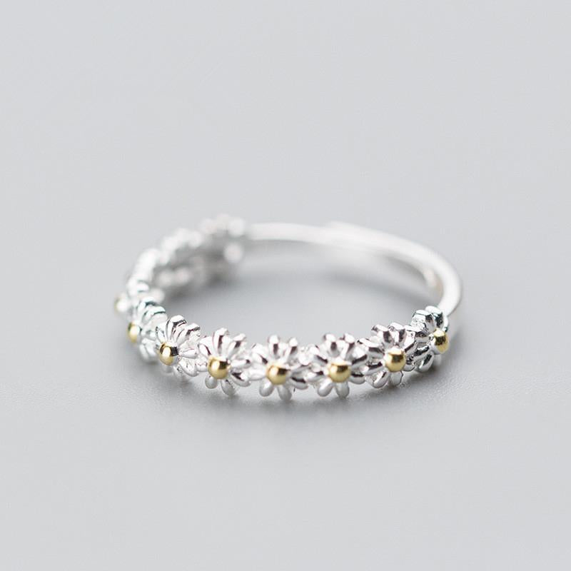 "Elegant justerbar ring för kvinnor med små tusenskönor, silverfärgad, symboliserar glädje och oskyldighet."