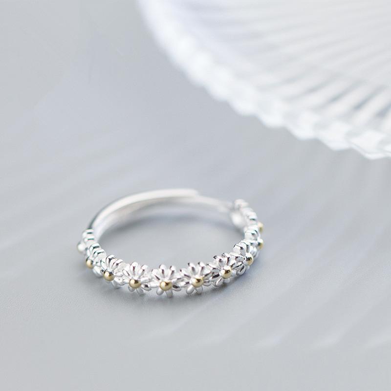 "Elegant justerbar ring för kvinnor med små tusenskönor, silverfärgad, symboliserar glädje och oskyldighet."