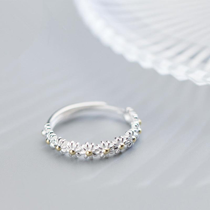 "Elegant justerbar ring för kvinnor med små tusenskönor, silverfärgad, symboliserar glädje och oskyldighet."