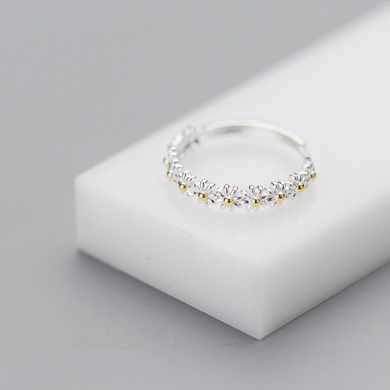 "Elegant justerbar ring för kvinnor med små tusenskönor, silverfärgad, symboliserar glädje och oskyldighet."