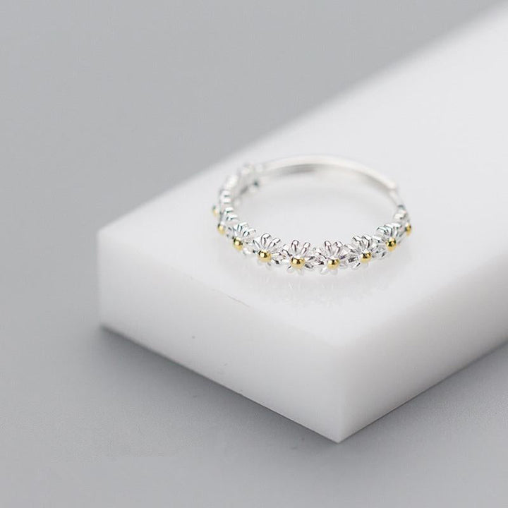"Elegant justerbar ring för kvinnor med små tusenskönor, silverfärgad, symboliserar glädje och oskyldighet."