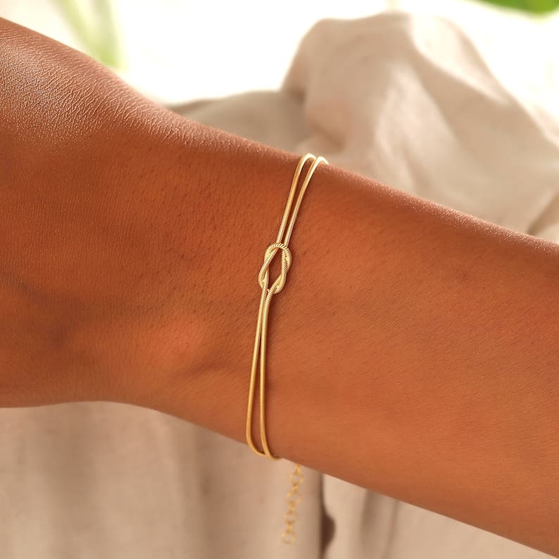 Elegant justerbart damarmband med tidlös kärleksknop design. Ett stilrent smycke för kvinnor.