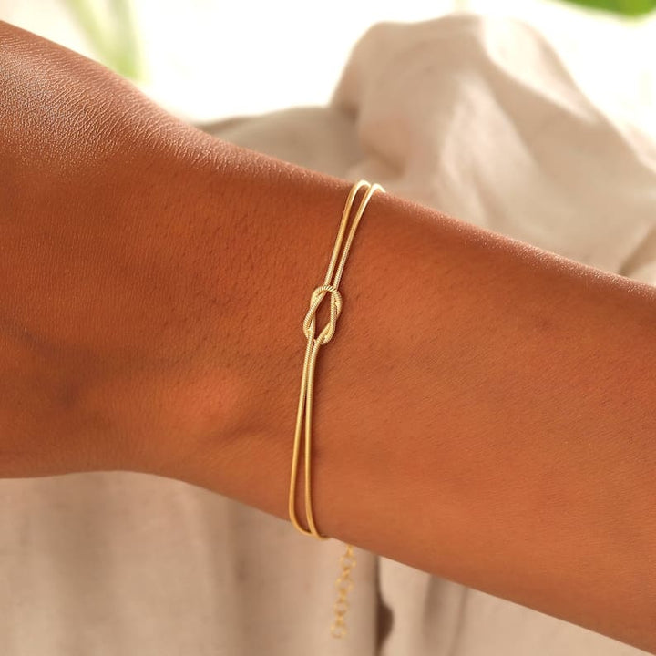 Elegant justerbart damarmband med tidlös kärleksknop design. Ett stilrent smycke för kvinnor.
