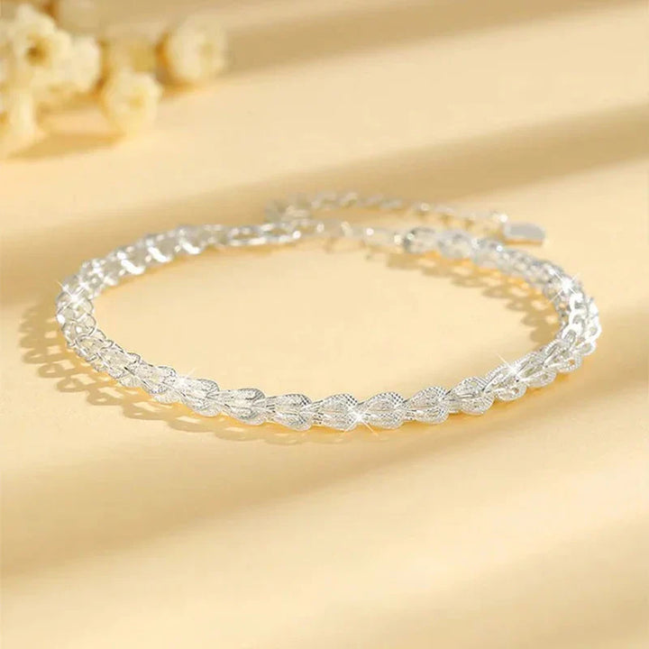 "Elegant justerbart Phoenix armband i guld/silver med unikt fjädermotiv, perfekt kvinnligt smycke för alla tillfällen."