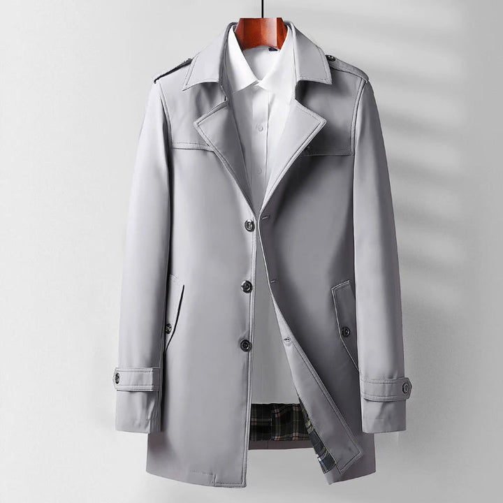 Man bär en snygg svart herr trenchcoat, frontvy, accentuerar dess klassiska stil för män.