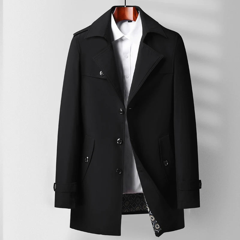Bakvy av en lång herr trenchcoat i marinblått, med sprund och bälte, tidlös höstkappa.