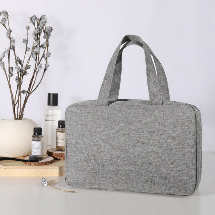 "Elegant kvinnors necessär med 4 fack, hängkrok, mjukt material, svart och rosa färgval, för resor och organisering."