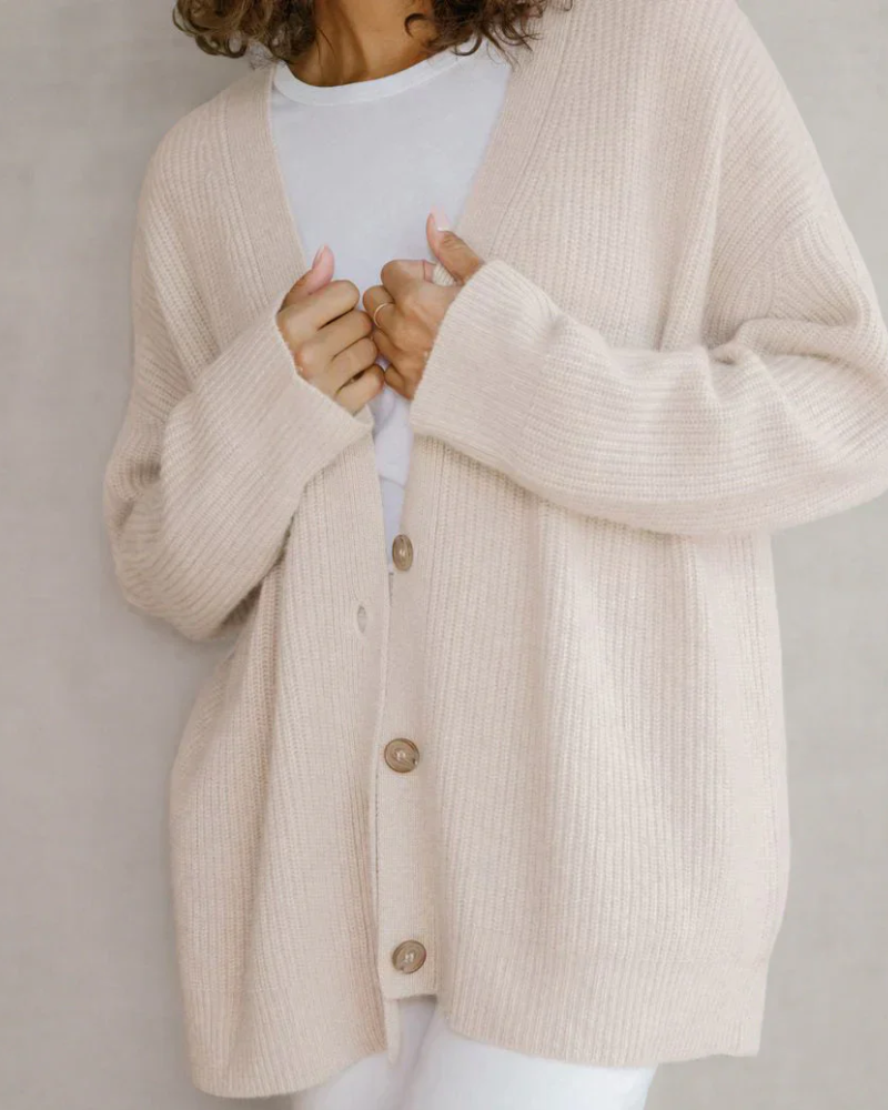 Sida vy av dam i flytande lång cardigan med öppen framkant, visar elegant silhuett. Damkläder.