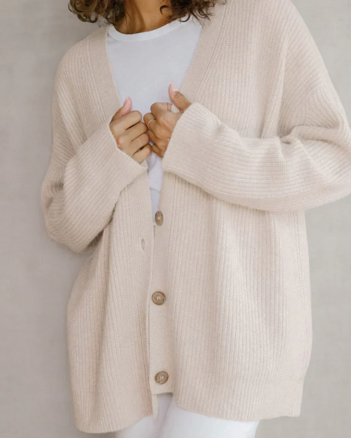 Sida vy av dam i flytande lång cardigan med öppen framkant, visar elegant silhuett. Damkläder.