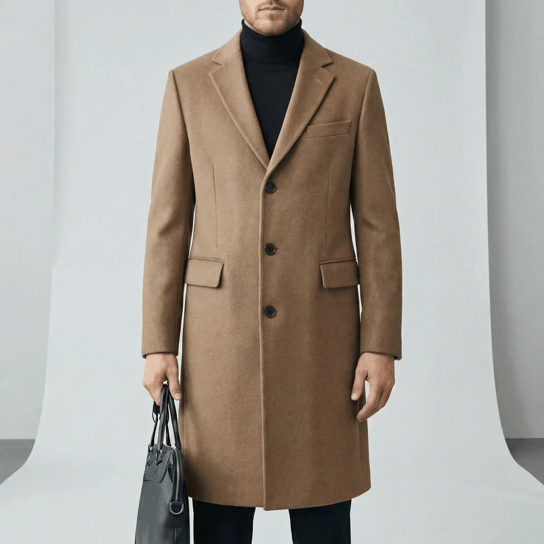 Man bär modern långrock med knapplist, idealisk som höst- eller vinterkappa. Tidlös design för män.