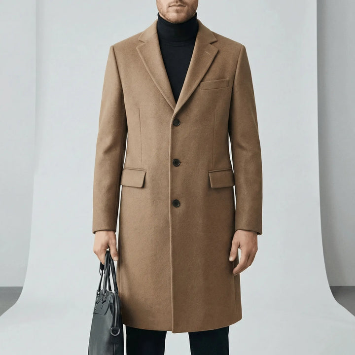 Man bär modern långrock med knapplist, idealisk som höst- eller vinterkappa. Tidlös design för män.