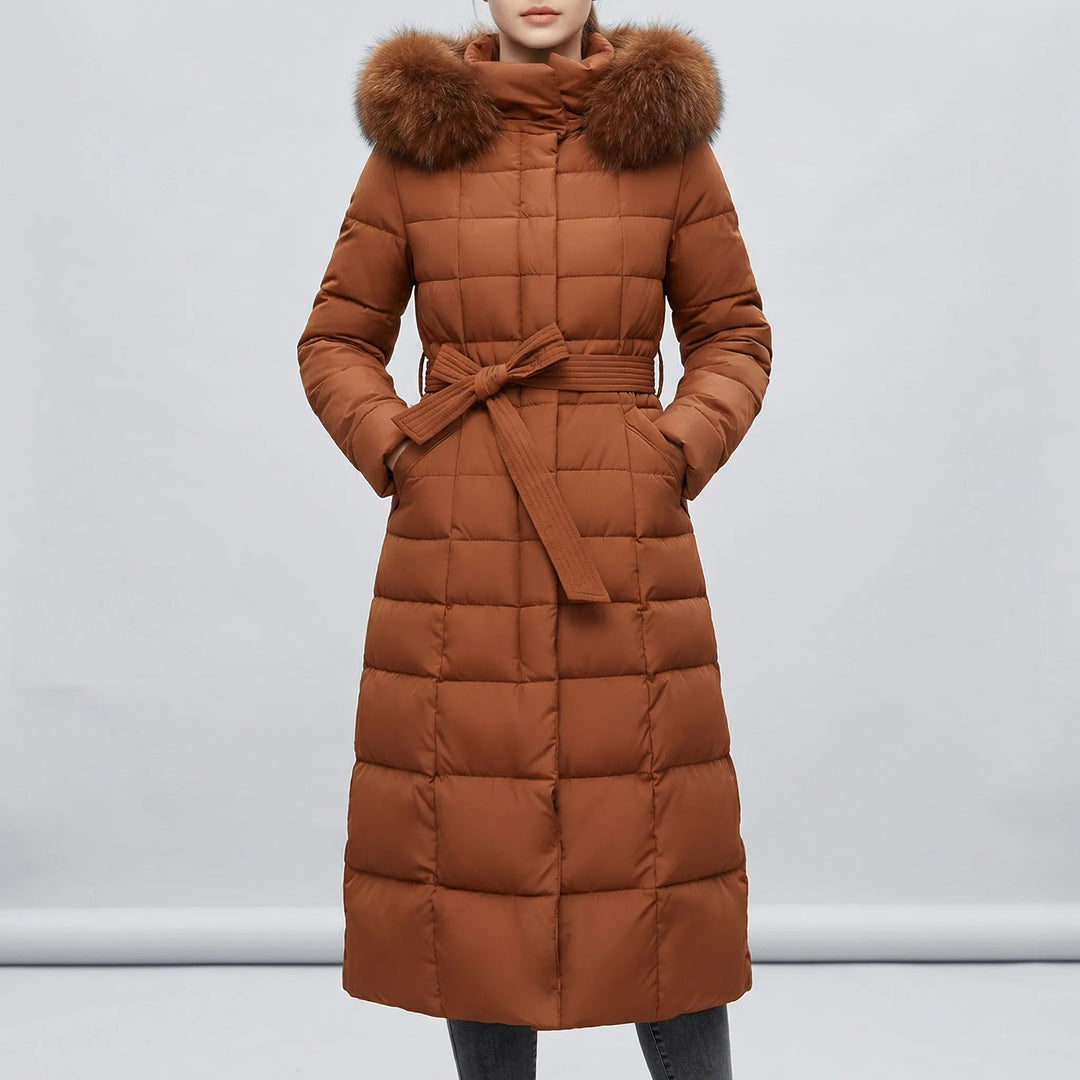 Kvinna bär lång vadderad dam vinterkappa 'Natalie' med huva. Ett modernt ytterplagg för en elegant look.