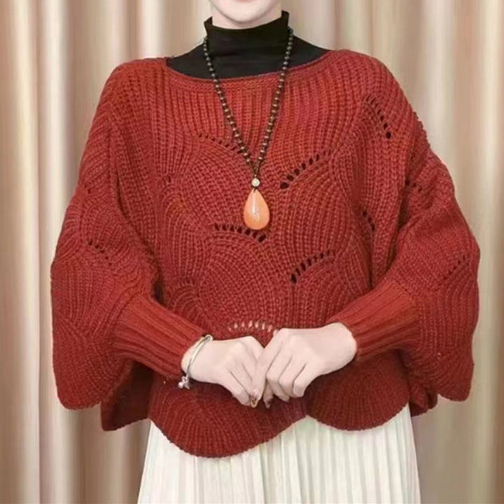 "Elegant långstickad damponcho med fladdermusärmar, ger stil och värme, i mjuk grå ton."
